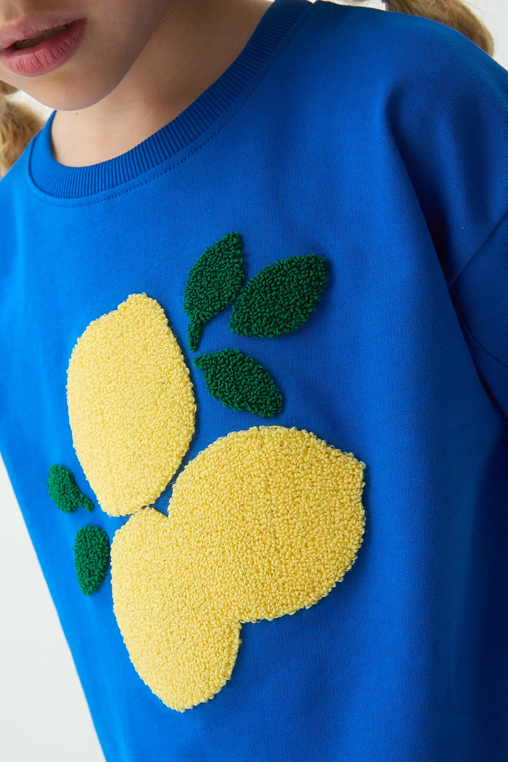 Sudadera de niña azul con parche de limones